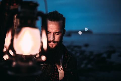 Man holding lamp in the darkness