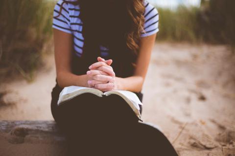 Woman praying with Bible