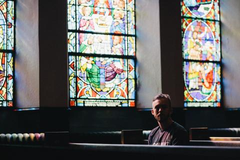 Young man sitting in pew